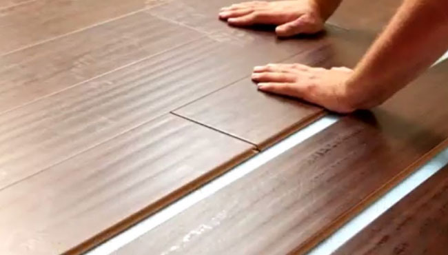 a person's hands on a wood floor