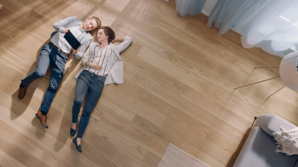 Young Couple are Lying on a Wooden Flooring