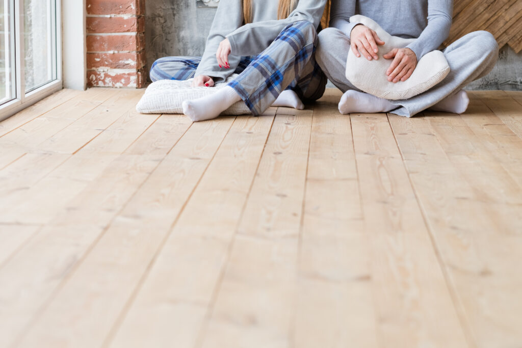 Couple with pillows sitting on floor