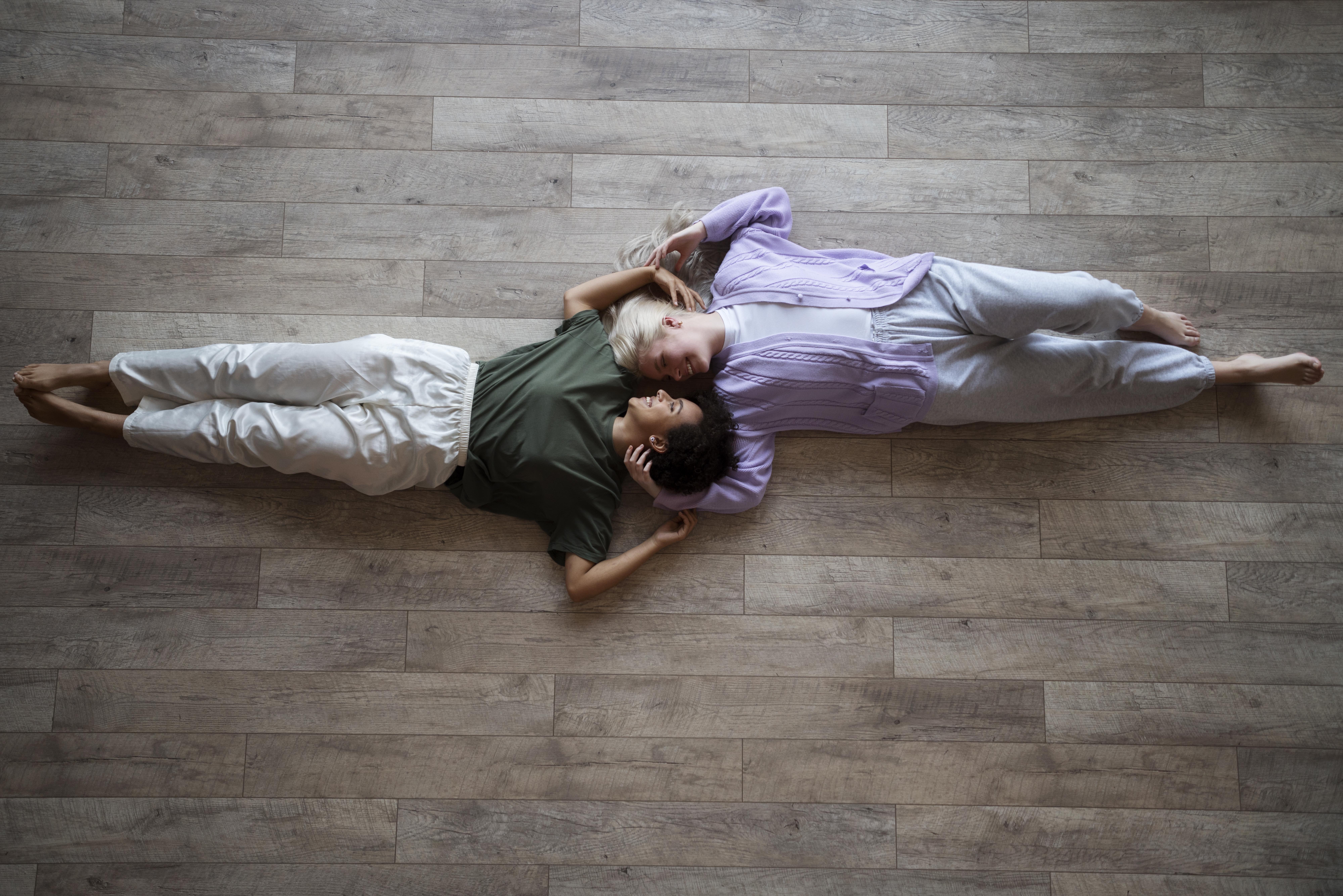 couple laying on a wooden floor